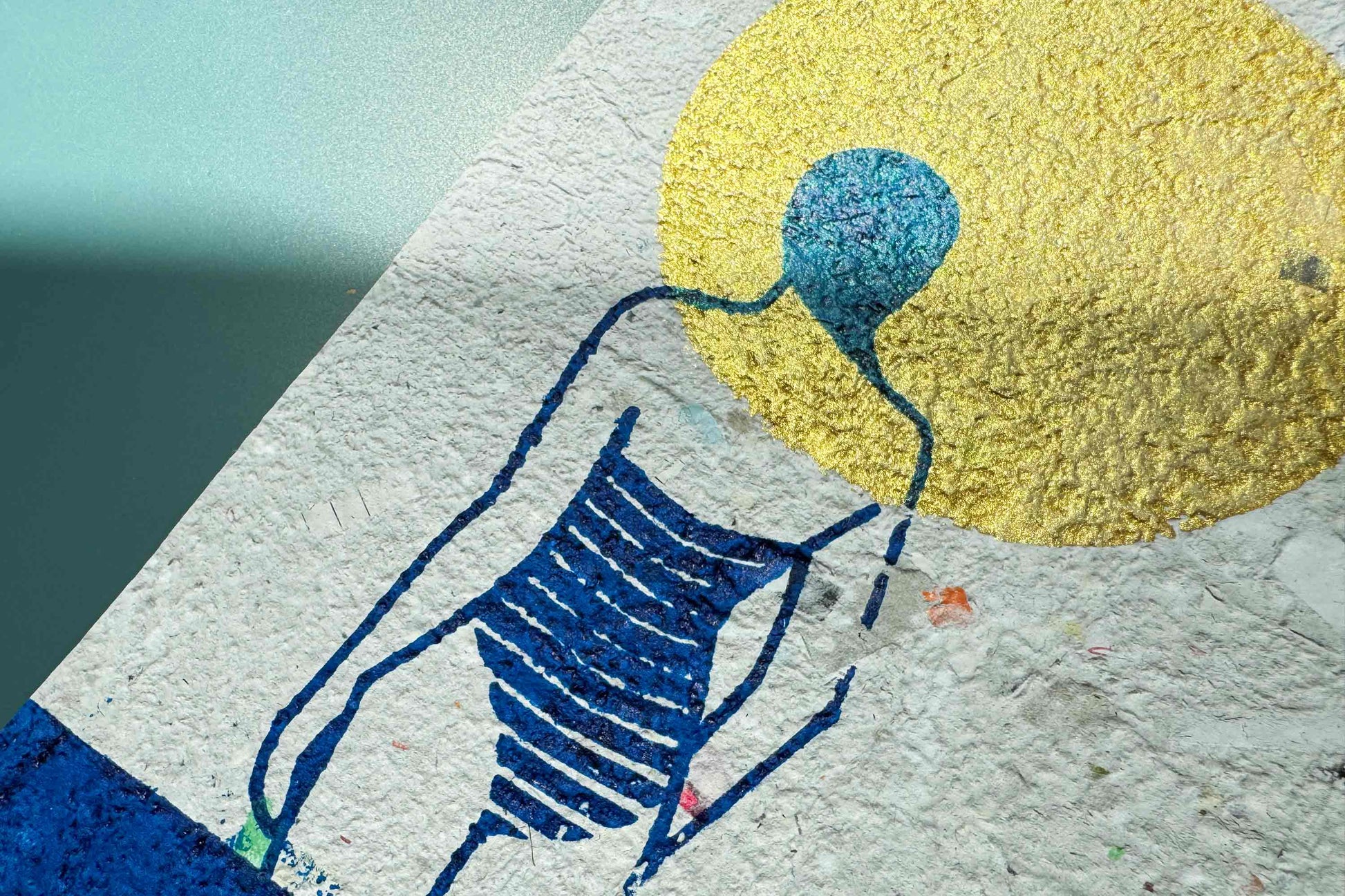 Detailansicht Siebdruckplakat Mare vor blauem Hintergrund: schimmerndene goldene Sonne, blaues Wasser und Silhouette die in die Ferne guckt. Handbedruckt auf selbst geschöptem, strukturiertem Papier, Upcycling Altpapier