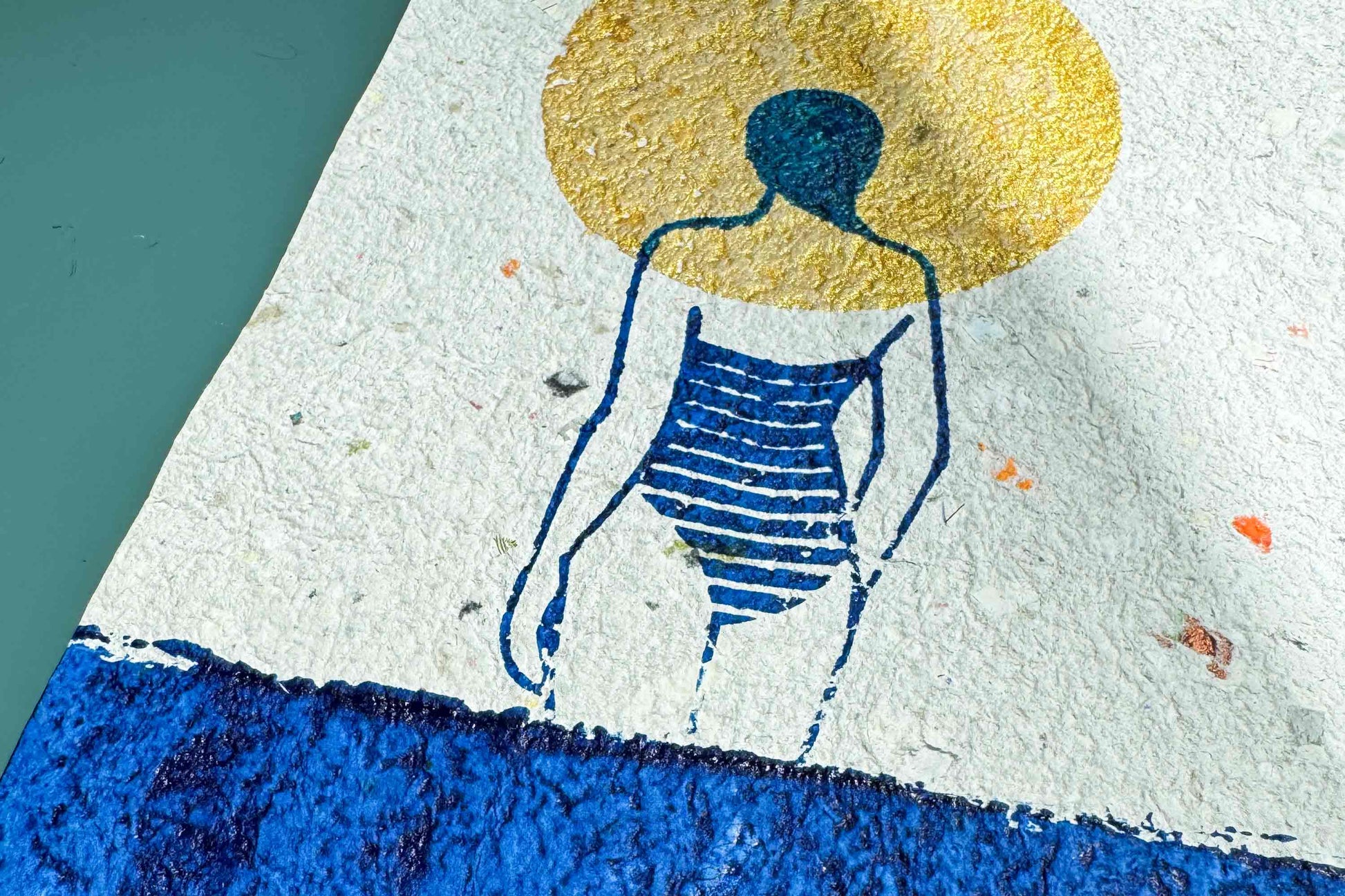 Detailansicht der Haptik des Siebdruckplakates Mare vor blauem Hintergrund: schimmerndene goldene Sonne, blaues Wasser und Silhouette die in die Ferne guckt. Handbedruckt auf selbst geschöptem, strukturiertem Papier, Upcycling Altpapier