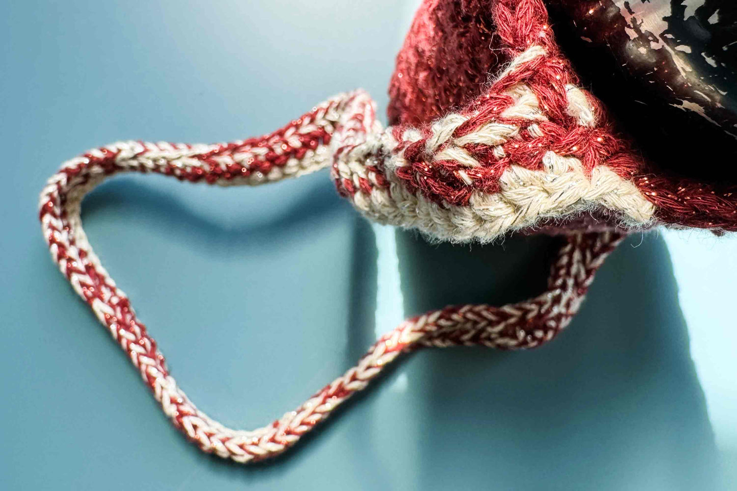 Häkeldetail des rot-beige glitzernden Flaschenhalters zum Umhängen CHRISTA mit Trinkflasche