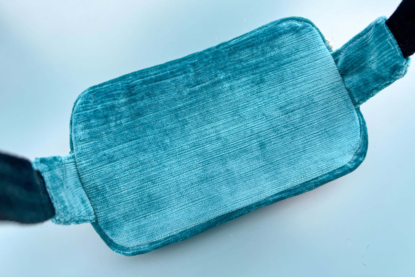 Hinteransicht einer Bauchtasche aus Samt von Jeff EveryPieceAFriend. Die Tasche ist blau und hat ein schwarzes Gurtband.