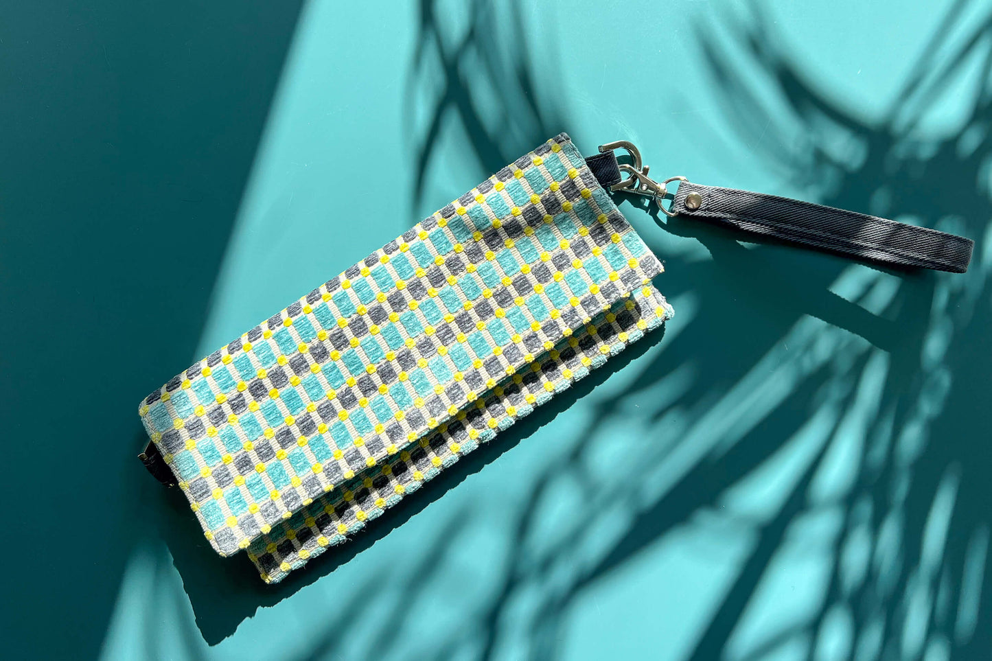 Gesamtansicht der kleinen Umhängetasche DANA aus upcycled Polsterstoff in den Farben blau, gelb und beige mit silbernen Verschlüssen.