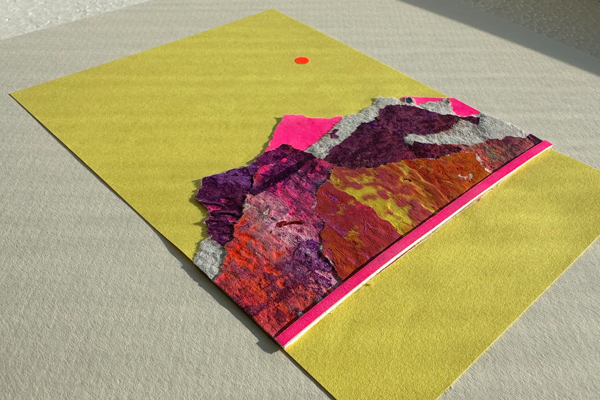 Collage von schräg oben zeigt eine abstrakte, pink-violette Bergkulisse auf gelben Hintergrund, umrahmt von einem weißen, großen Passepartout. jeff-everyPieceAFriend