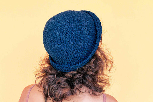 Frau mit Locken trägt blauen gehäkelten Anglerhut aus Garn aus zweiter Hand von jeff every piece a friend