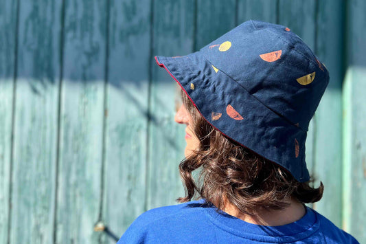 Frau trägt wendbaren Anglerhut aus Jeansupcycling mit goldenen und bronze Siebdruck-Formen