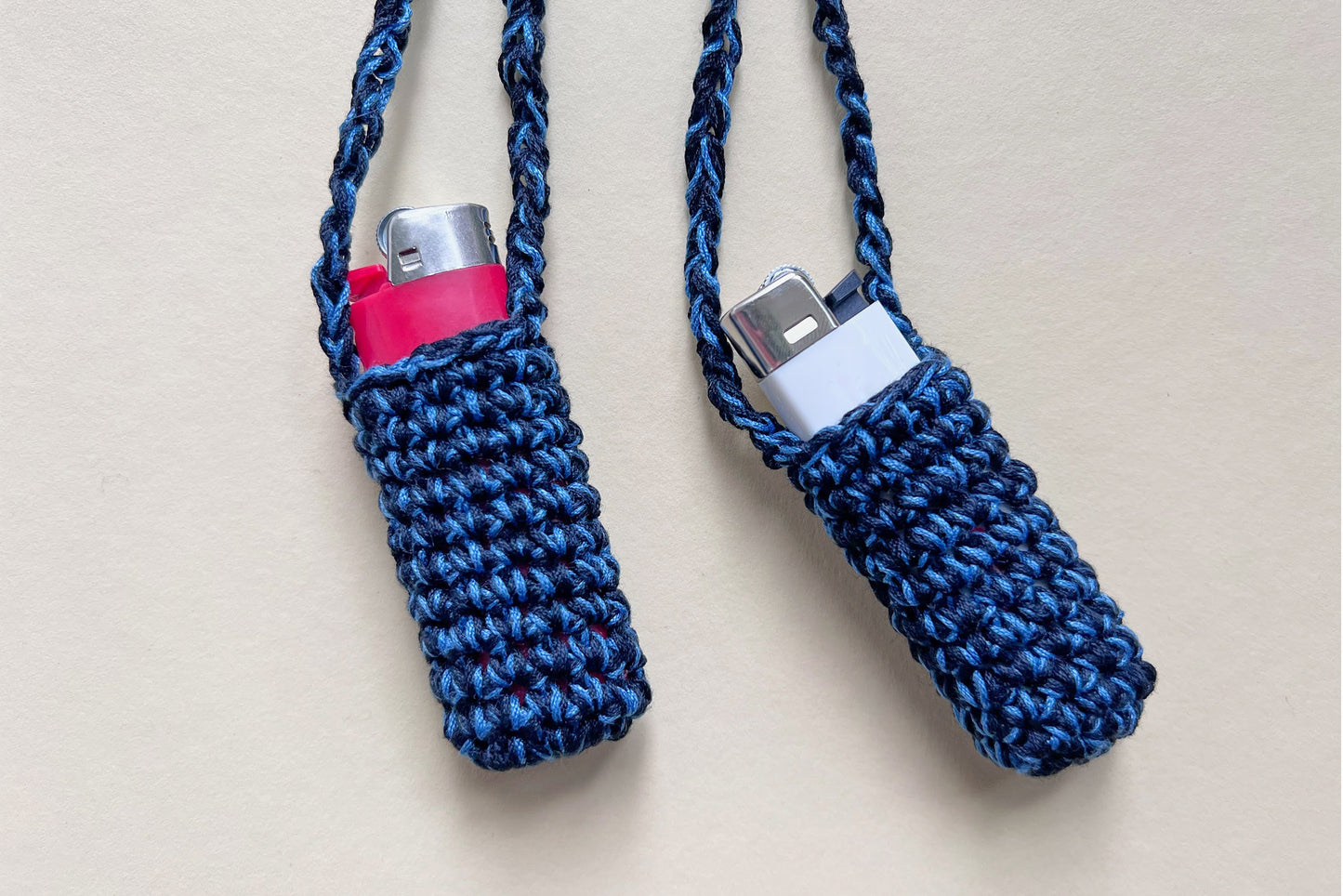 Zwei blaue gehäkelte Feuerzeughalter als Halsketten