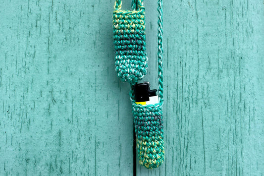 Zwei gehäkelte Taschen fürs Feuerzeug in verschiedenen Grüntönen.