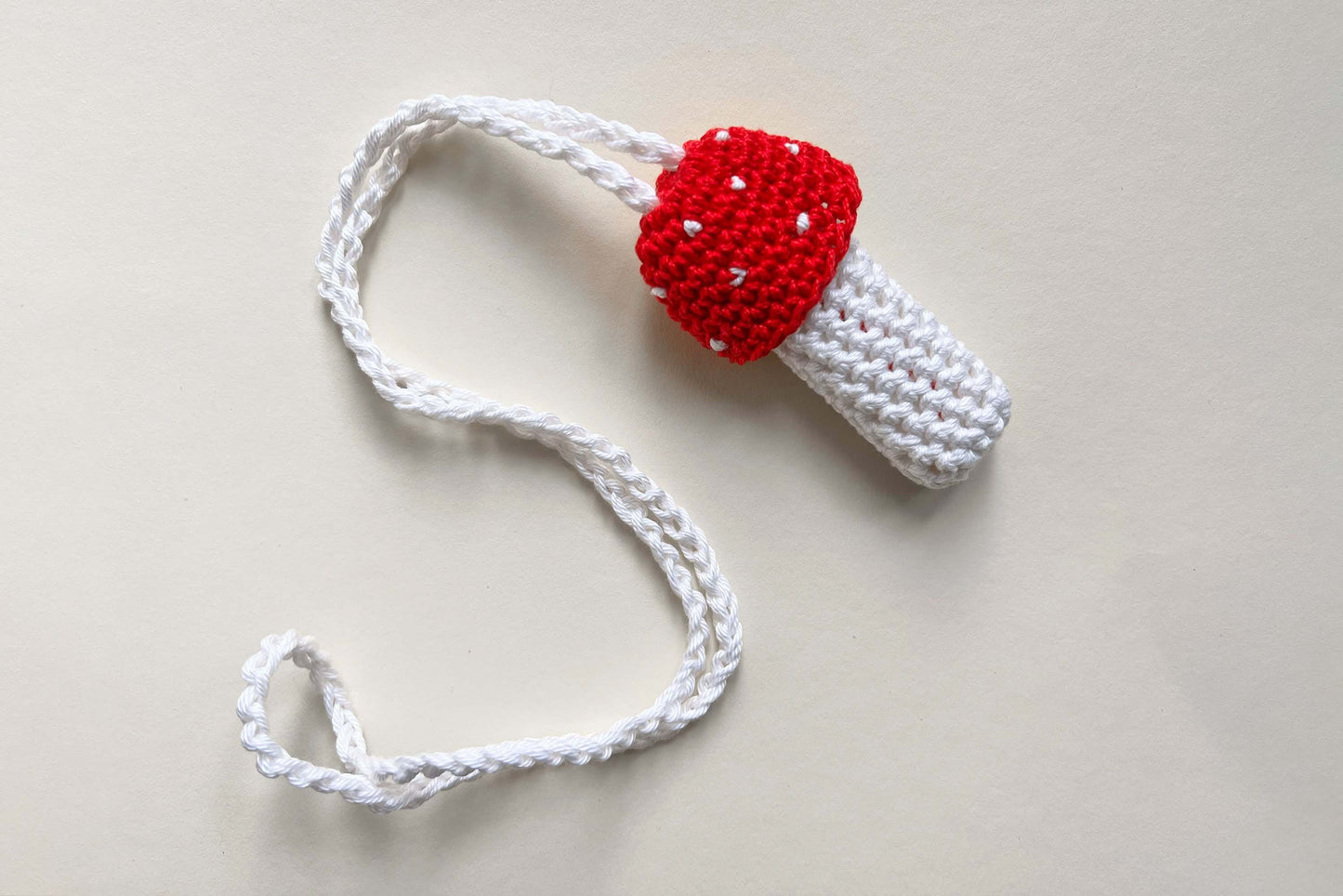 Ein gehäkelter Feuerzeughalter zum Umhängen in Fliegenpilzoptik