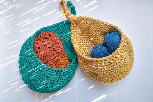 Zwei gehäkelte Wandkörbe in gelb und blau zum Aufbewahren von Utensilien