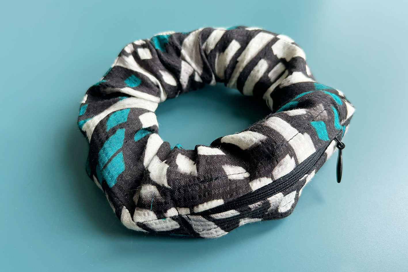 Schwarz, weiß und grün gemustertes Haarband mit Geheimfach und Reißverschluss. Scrunchie hergestellt aus Upcycling Materialien.