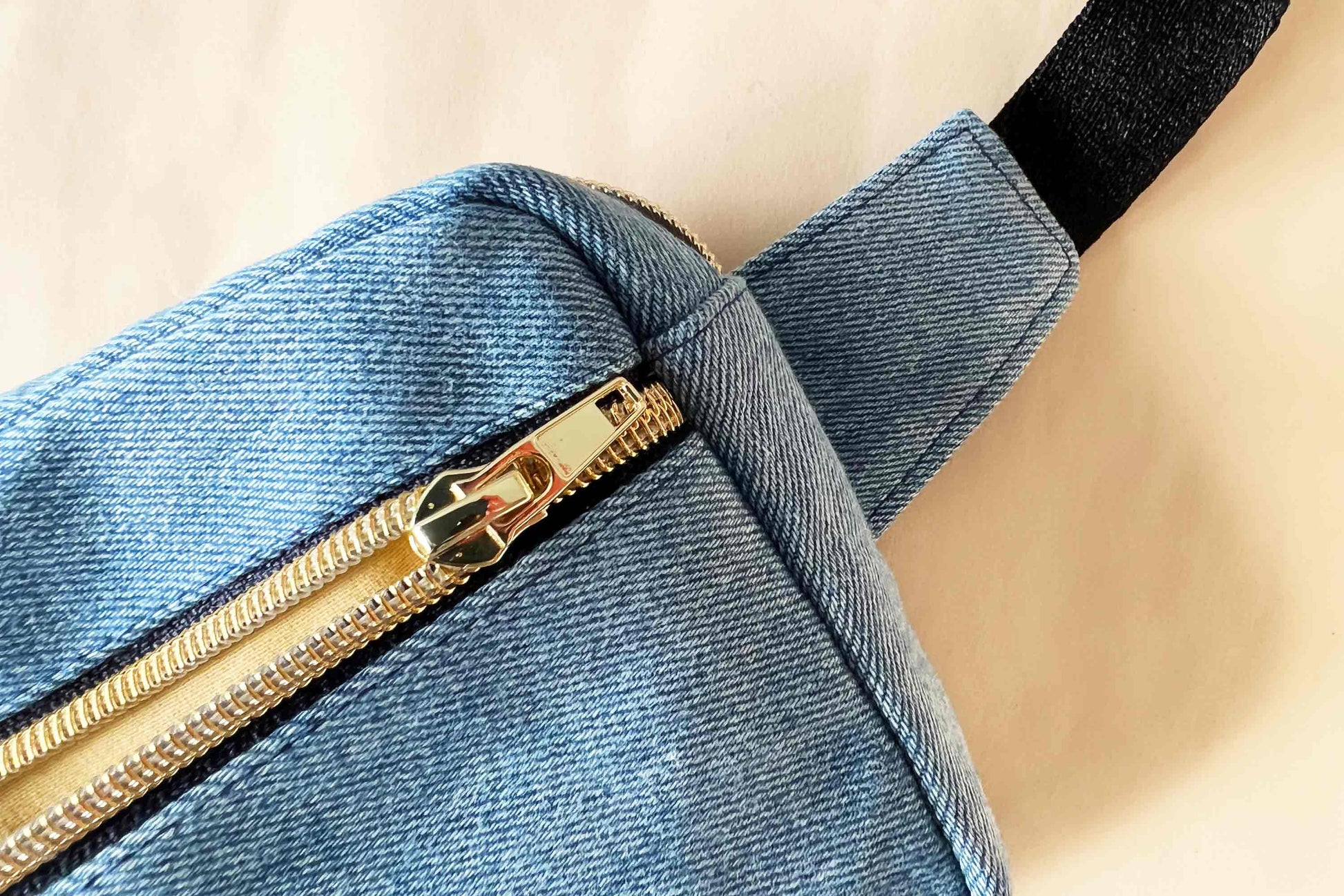 Detail goldener Reisverschluss bei hellblauer Hipbag aus upgecyelten Jeans von jeff every piece a friend