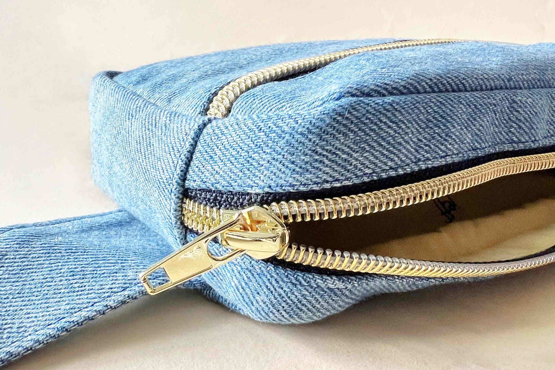 Detail goldener Reisverschluss bei hellblauer Hipbag aus upgecyelten Jeans von jeff every piece a friend
