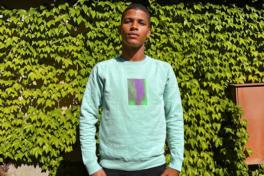 Mann trägt mintfarbenes Unisex Sweatshirt mit grün lila verlaufendem Druck von einem Rechteck auf der Brust, bedruckt mit Siebdruck.
