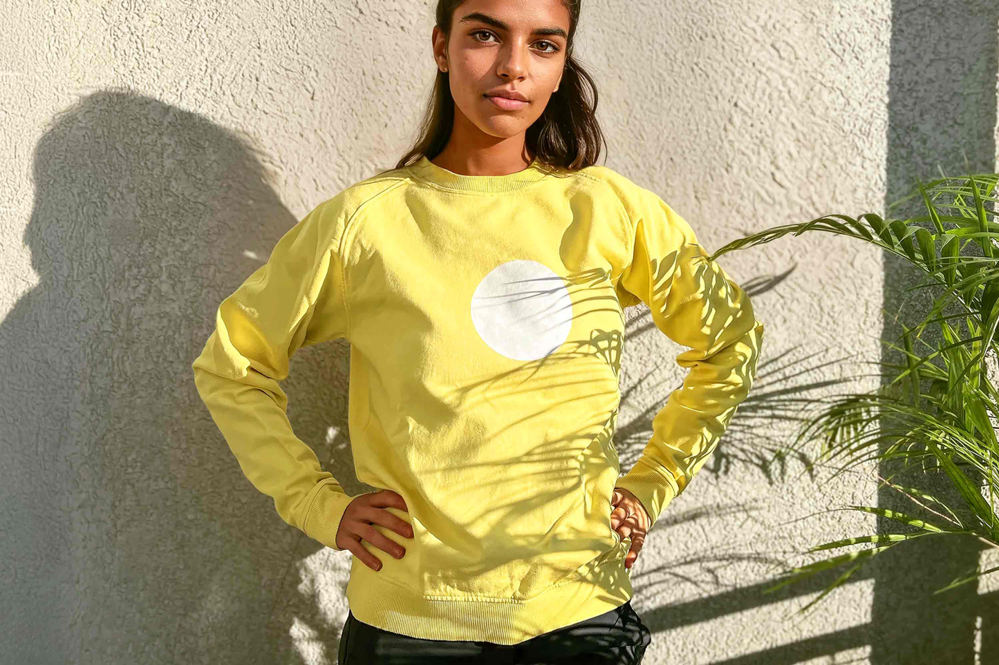 Hübsche Frau trägt ein gelbes Unisex Sweatshirt mit einem weißen Kreis, handbedruckt mit Siebdruck