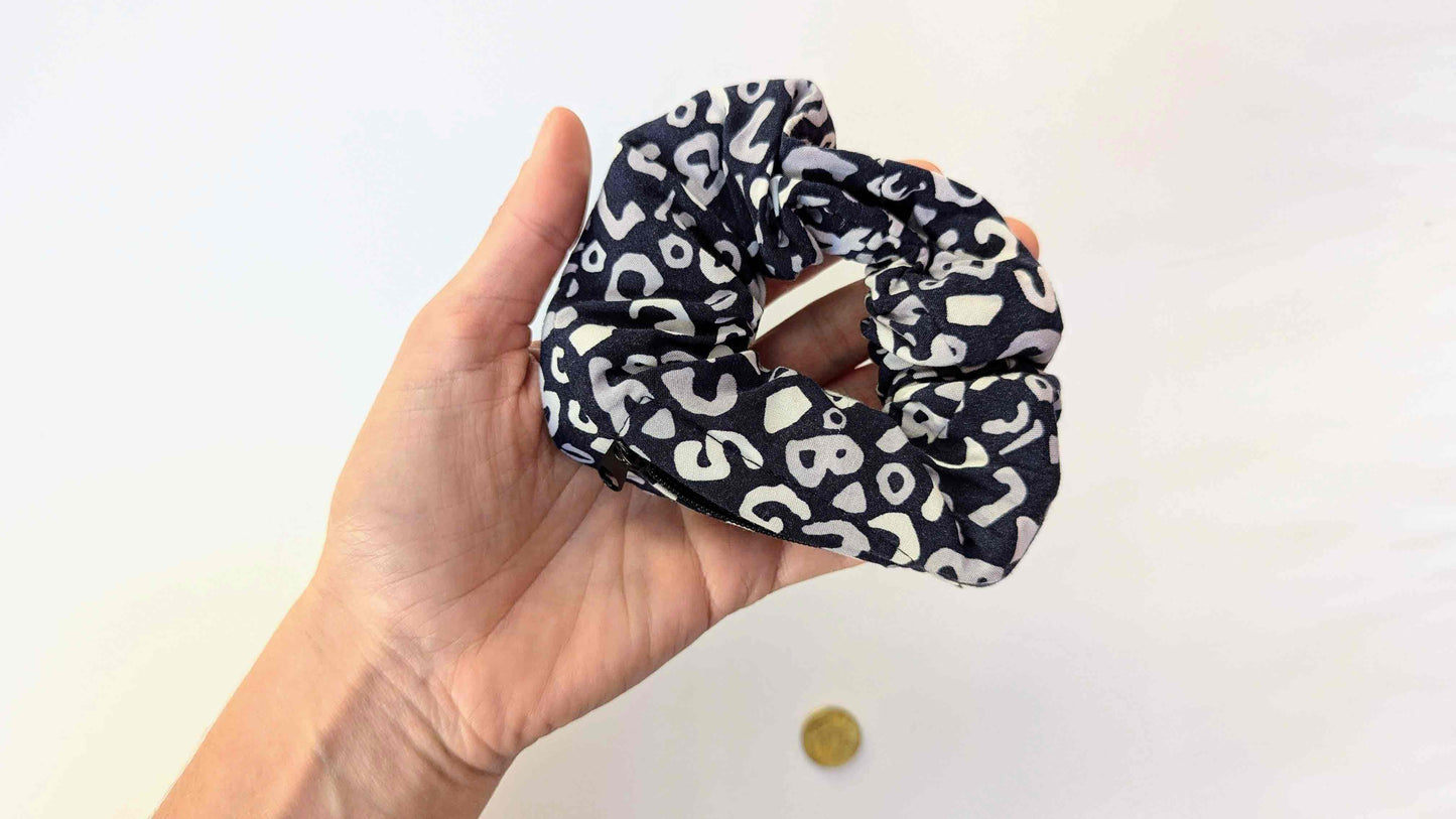 Blau weißes Leoprint Haarband, Scrunchie TRULLA mit Reisverschlussfach liegt in Hand einer Frau