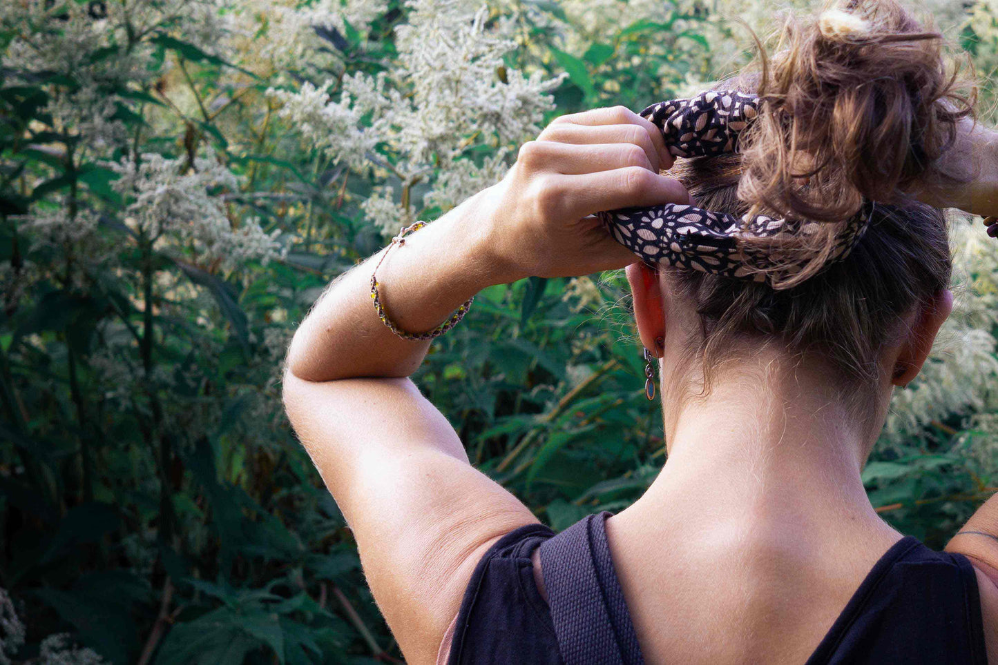 Frau bindet sich einen Pony mit Scrunchie TRULLA mit Reisverschlussfach, aus Upcycling Material