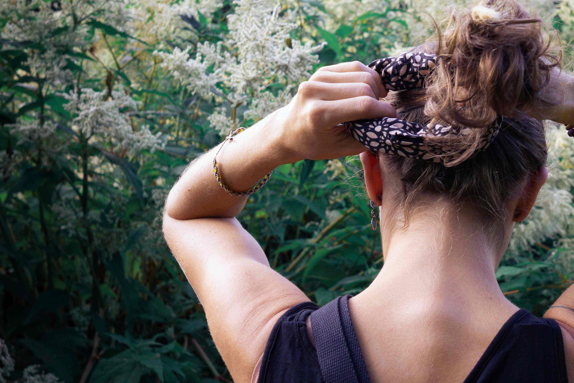 Frau bindet sich einen Pony mit Scrunchie TRULLA mit Reisverschlussfach, aus Upcycling Material