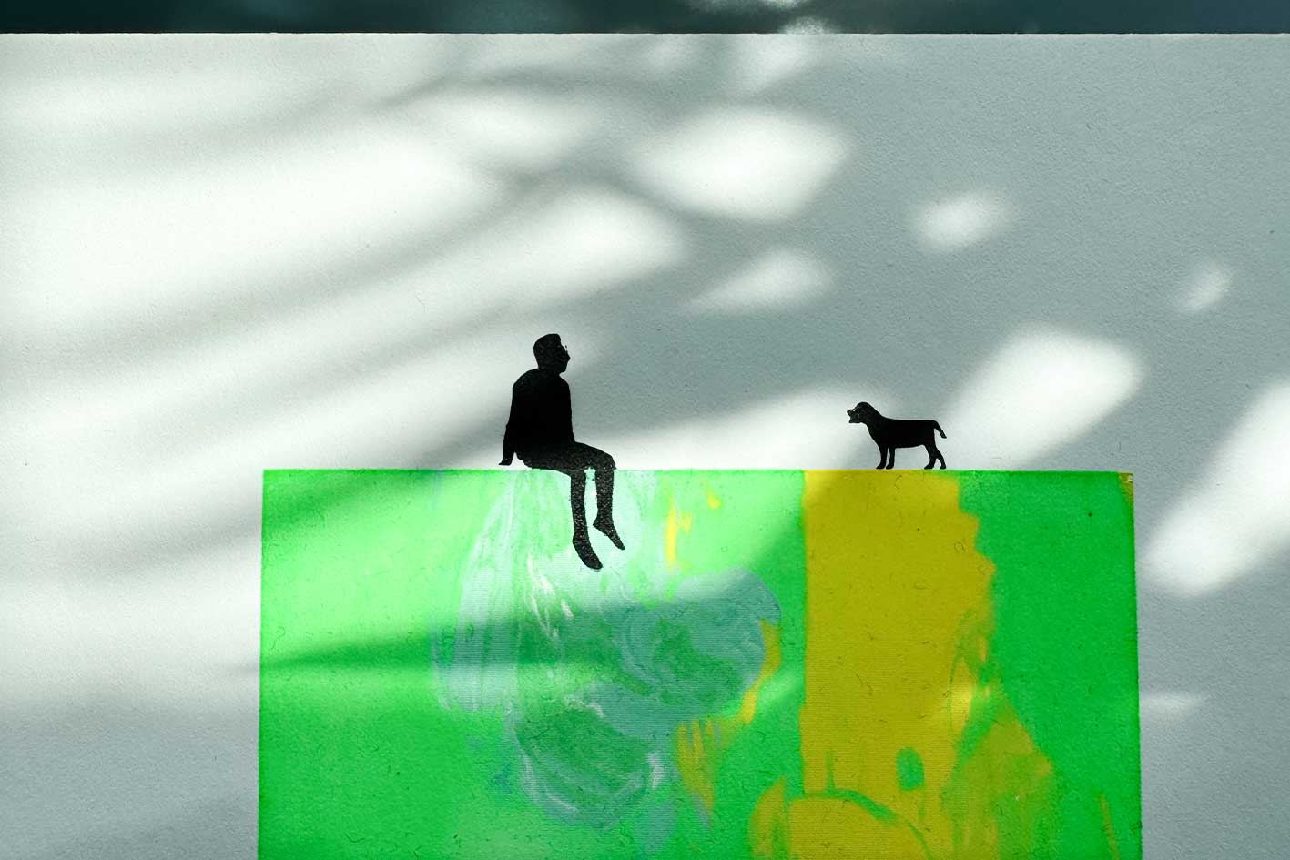 Detailansicht von Siebdruck MILO, kleine männliche schwarze Figur und Hund sitzen auf grün gelber Fläche in Neonfarben