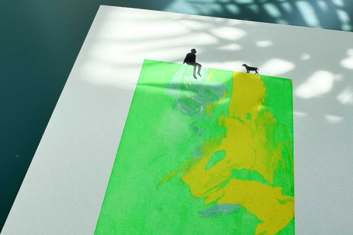 Detailansicht von Siebdruck MILO, kleine männliche schwarze Figur und Hund sitzen auf grün gelber Fläche in Neonfarben