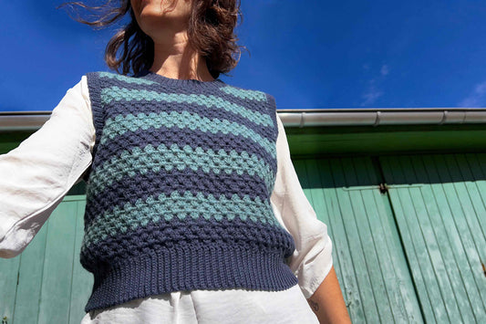 Frau trägt blauen Pullunder TONI, mit Wellenmuster, gehäkelt mit Wolle aus zweiter Hand