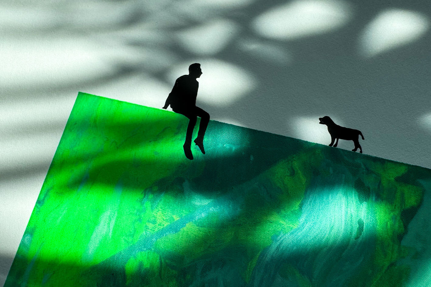 Detailansicht von Siebdruck MILO, kleine männliche schwarze Figur und Hund sitzen auf grün gelber Fläche in Neonfarben