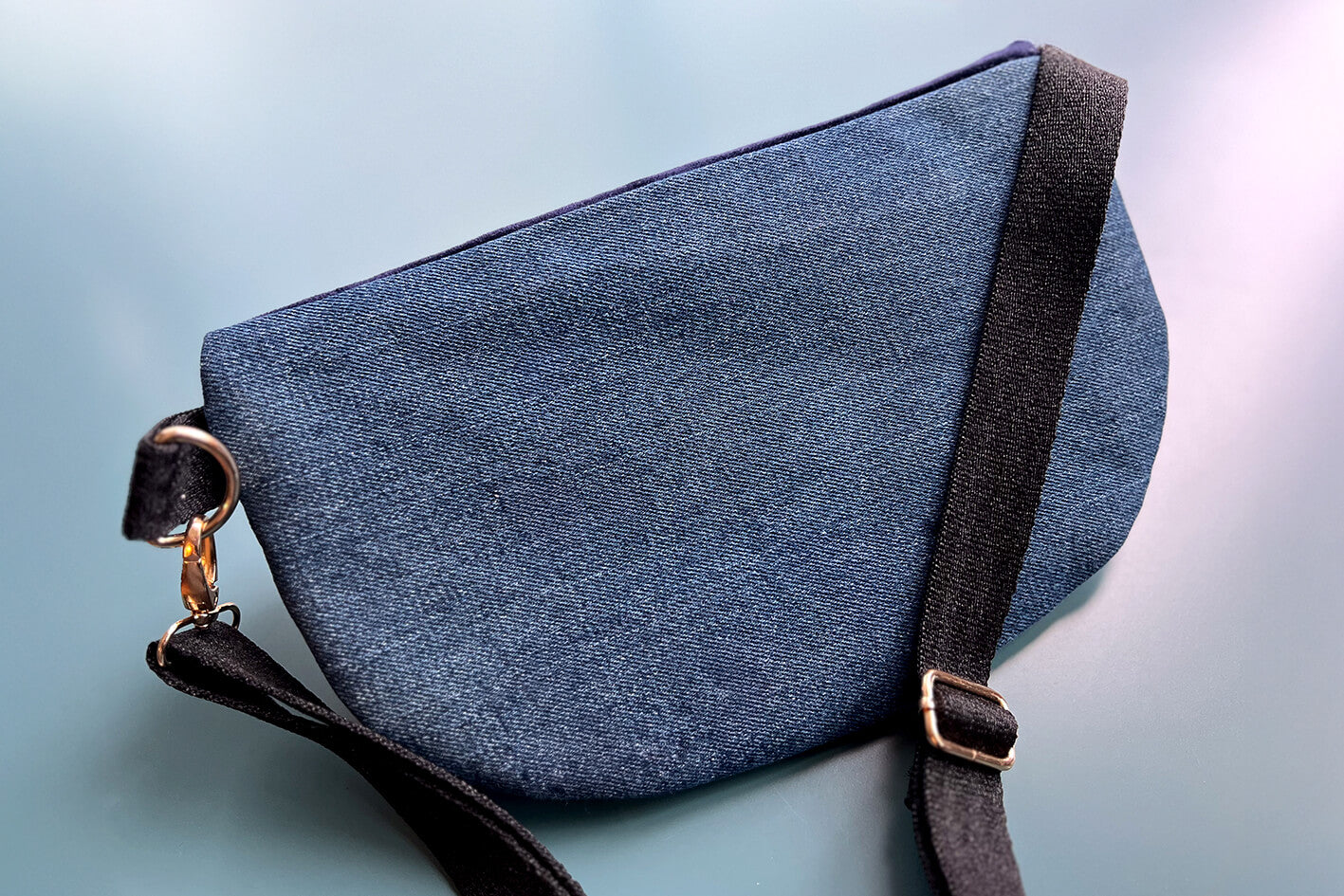 Gesamtansicht Rückenansicht einer großen Bauchtasche aus upcycled Denim. Die Tasche hat ein schwarzes Gurtband.