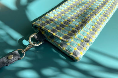 Detailansicht der kleinen Umhängetasche DANA aus upcycled Polsterstoff in den Farben blau, gelb und beige mit silbernen Verschlüssen. 