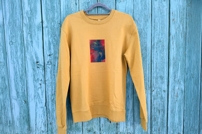 Frontansicht von senffarbenem senffarbenes Unisex Sweatshirt mit rot-blau-gelb verlaufendem Druck von einem großen Rechteck auf der Brust, bedruckt mit Siebdruck. 