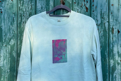 Detailansicht von hellblauen Unisex Sweatshirt mit lila-grün verlaufendem Druck von einem großen Rechteck auf der Brust, bedruckt mit Siebdruck. Siebdruck von Jeff EveryPieceAFriend.