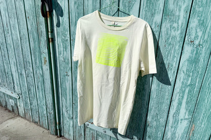 Detailansicht von einem hellgelben T-Shirt vor in der Größe S vor einem blau Hintergrund. Das T-Shirt hat einen welligen, neongelben Druck auf der Brust. Handbedruckt von Jeff - EveryPieceAFriend
