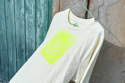 Detailansicht von einem hellgelben T-Shirt vor in der Größe S vor einem blau-beigen Hintergrund. Das T-Shirt hat einen welligen, neongelben Druck auf der Brust. Handbedruckt von Jeff - EveryPieceAFriend
