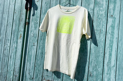 Detailansicht von einem hellgelben T-Shirt in der Größe S vor einem blauen Hintergrund. Das T-Shirt hat einen welligen, neongelben Druck auf der Brust. Handbedruckt von Jeff - EveryPieceAFriend