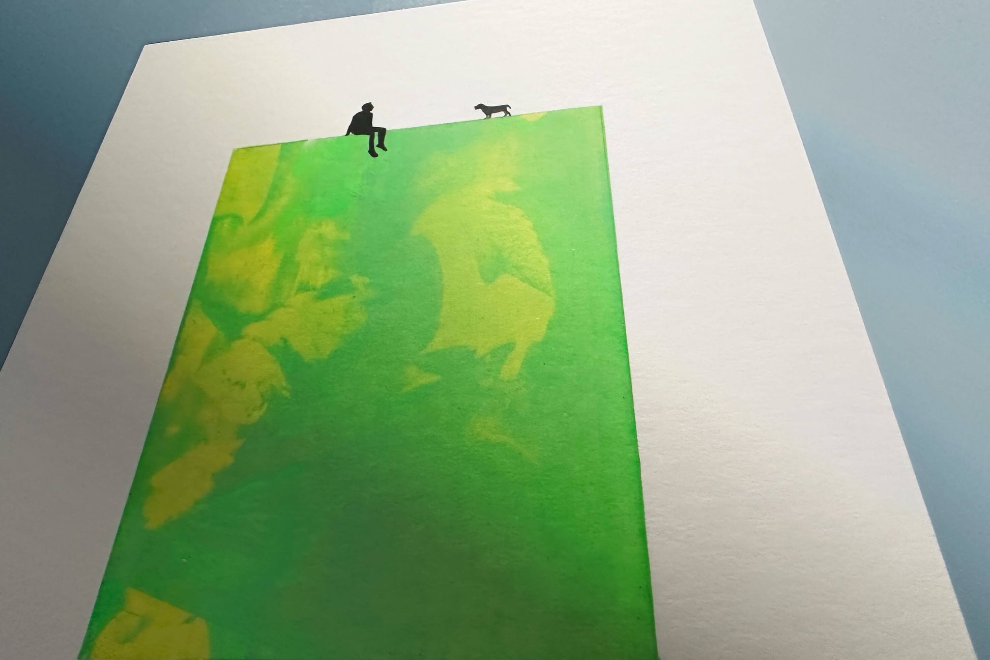 Detail Siebdruck gruen gelb MILO Figur mit Hund auf Passpartoutverschnitt 20x26,5cm zu sehen auf blauer Wand
