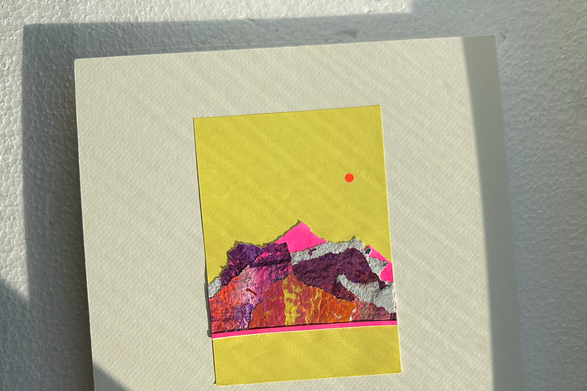 Collage von schräg vorne zeigt eine abstrakte, pink-violette Bergkulisse auf gelben Hintergrund, umrahmt von einem weißen, großen Passepartout. jeff-everyPieceAFriend