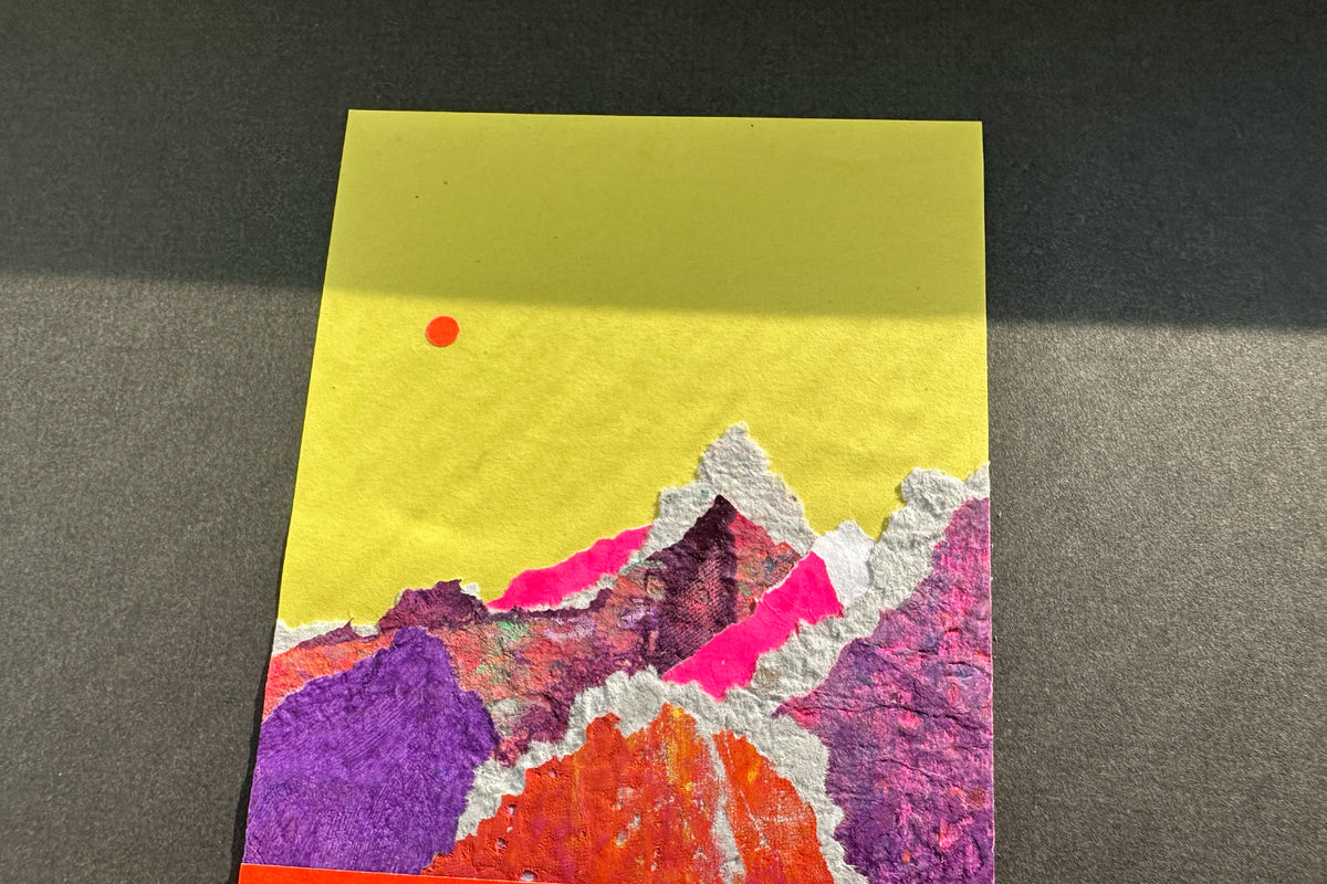 Collage von schräg oben zeigt eine abstrakte, pink-violette Bergkulisse auf gelben Hintergrund, umrahmt von einem schwarzen, großen Passepartout. jeff-everyPieceAFriend