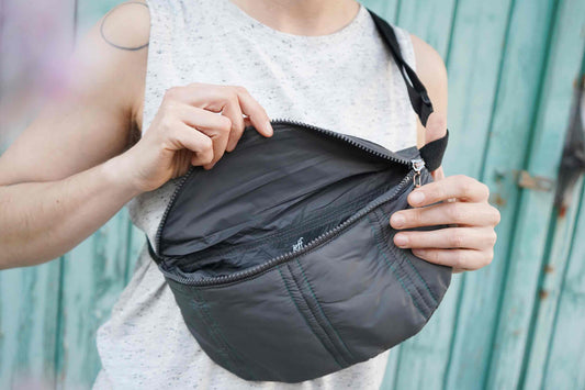 Frau trägt Bauchtasche aus Upcycling einer grauen Pufferjacke