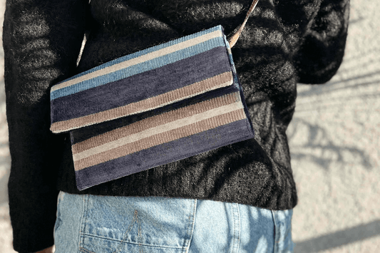 Close up der umgehängten Clutch zum DANA aus upcycling aus gelb beigem Polsterstoff. 
