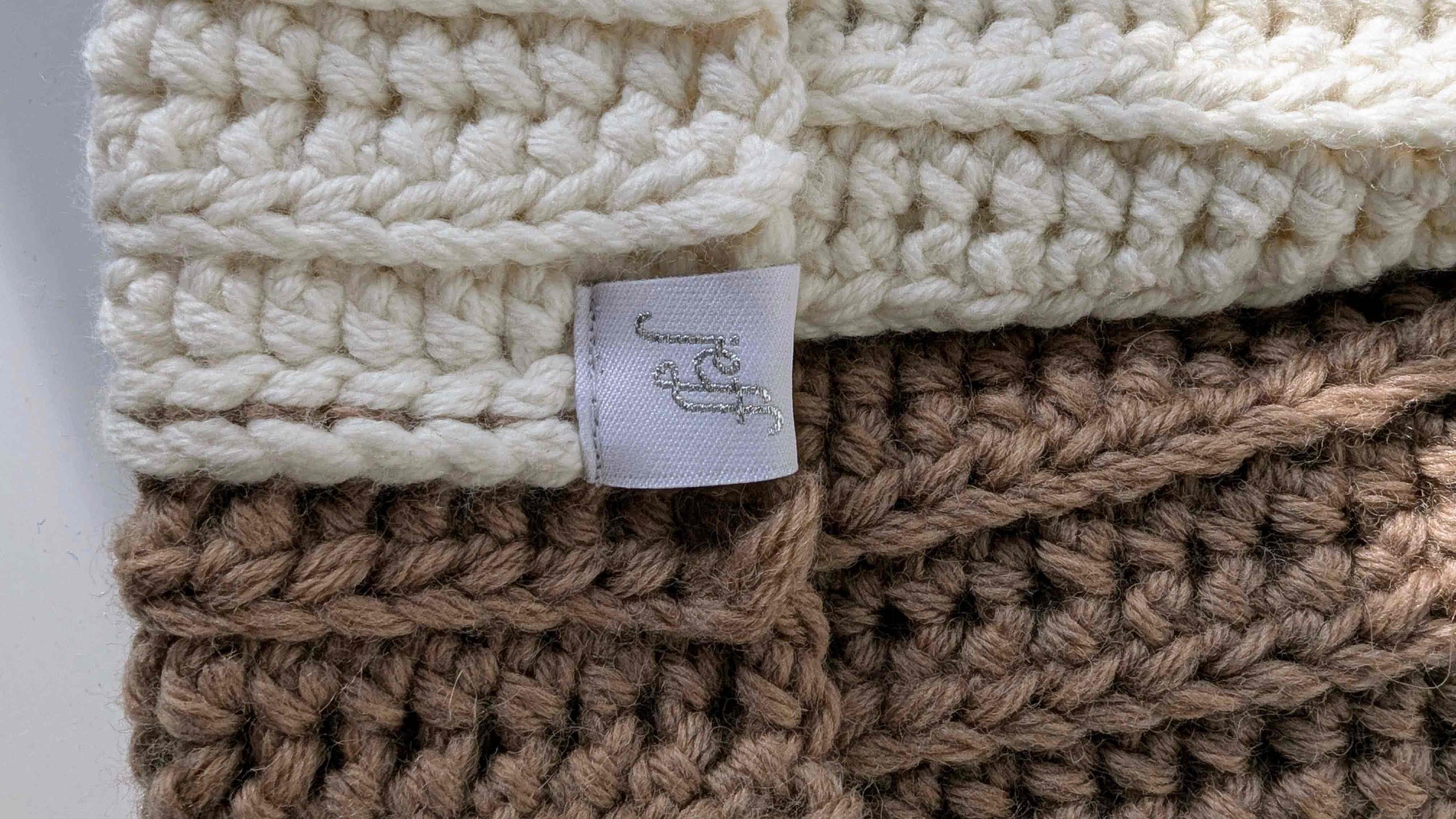 Detail jeff Logo auf braun weiß gehäkelter Wintermütze MAX