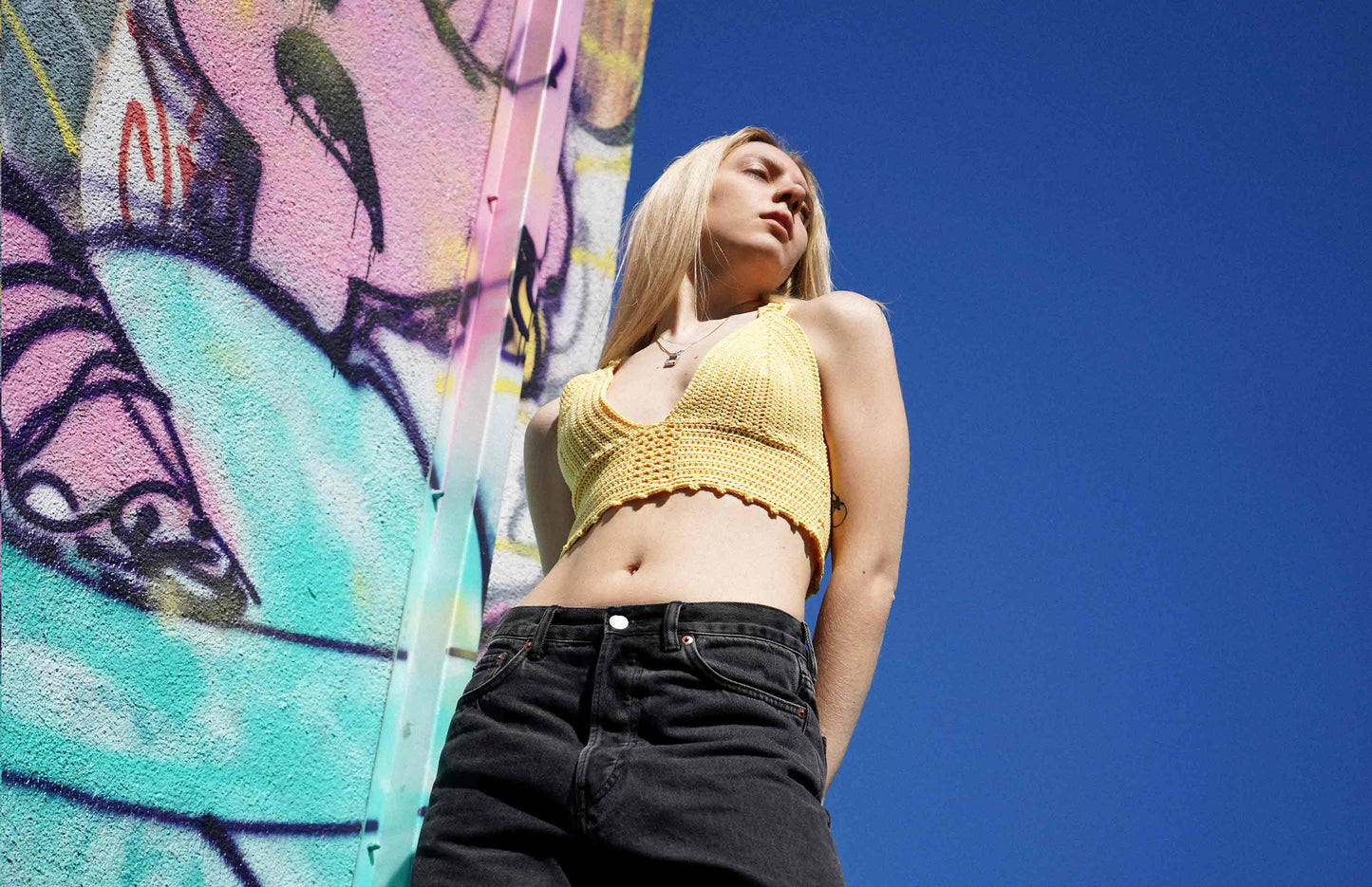 Junge Frauen trägt bauchfreies gelbes Häkeltop YAEL, aus Wolle aus zweiter Hand gehäkelt von jeff every piece a friend